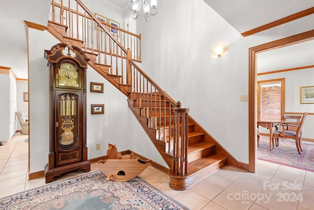 staircase with crown molding, tile patterned floors, and a notable chandelier