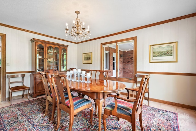 dining room featuring tile patterned floors, ornamental molding, and an inviting chandelier