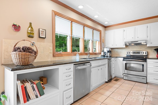 kitchen featuring tasteful backsplash, dark stone countertops, light tile patterned floors, stainless steel appliances, and white cabinets