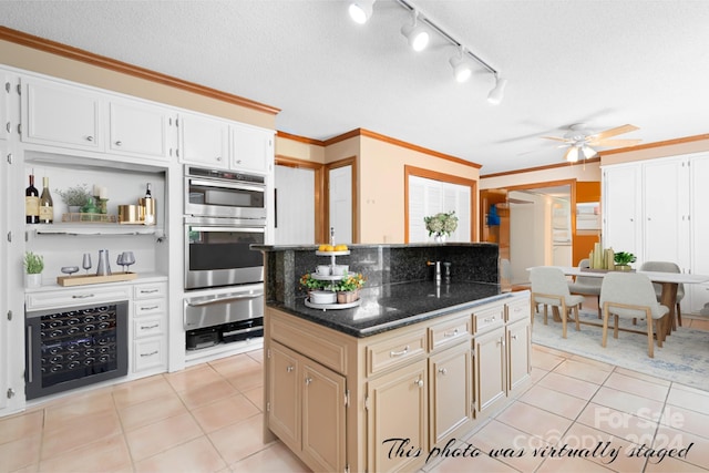 kitchen with a textured ceiling, light tile patterned flooring, dark stone counters, and a kitchen island