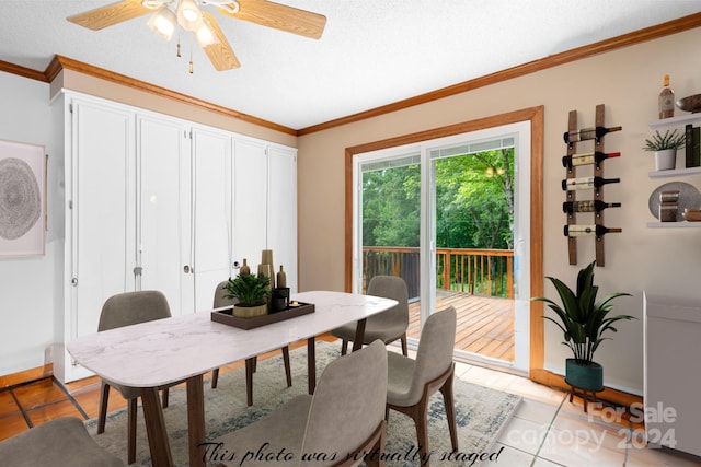 dining room with ceiling fan, a textured ceiling, ornamental molding, and light tile patterned flooring