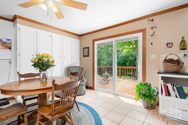 dining area featuring ceiling fan, light tile patterned flooring, ornamental molding, and a textured ceiling