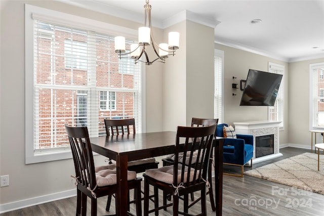 dining area with crown molding, dark wood-type flooring, a chandelier, and plenty of natural light