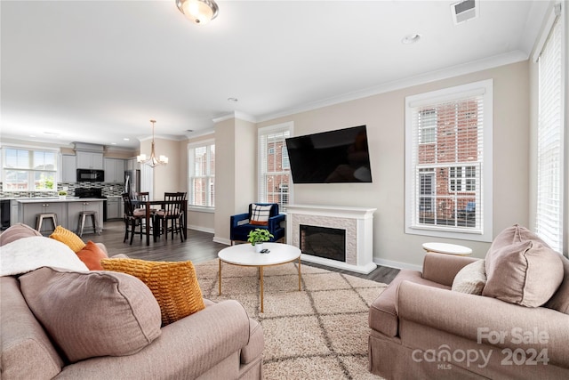 living room with ornamental molding, hardwood / wood-style floors, and a notable chandelier