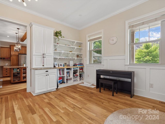 misc room with crown molding, light wood-type flooring, and a notable chandelier