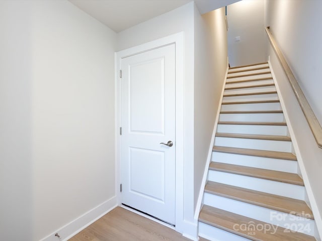 staircase with baseboards and wood finished floors