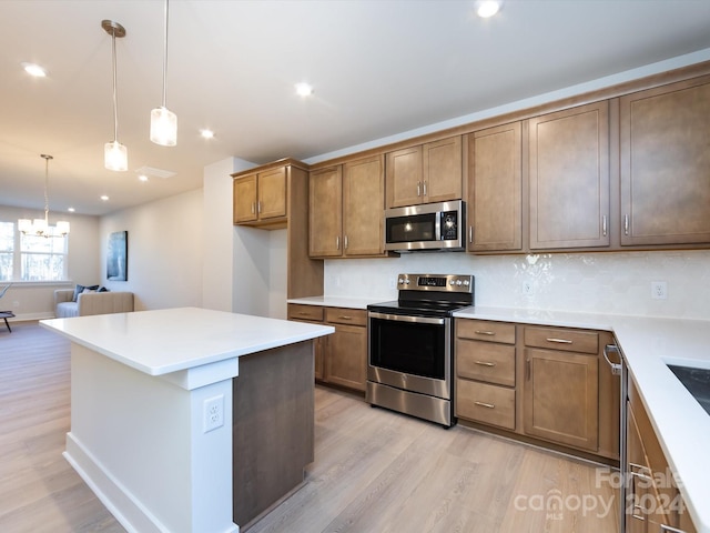 kitchen with light wood-style flooring, brown cabinets, open floor plan, stainless steel appliances, and light countertops