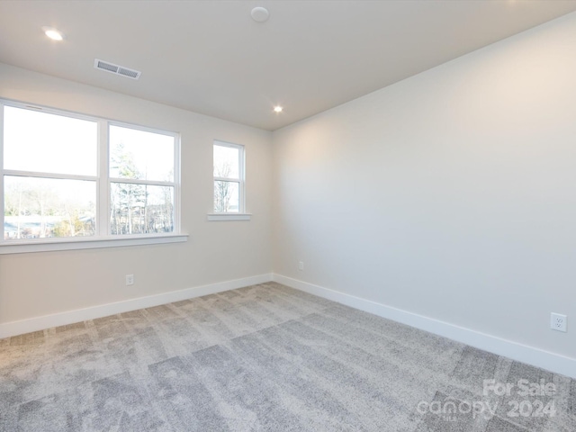 unfurnished room featuring recessed lighting, light colored carpet, visible vents, and baseboards