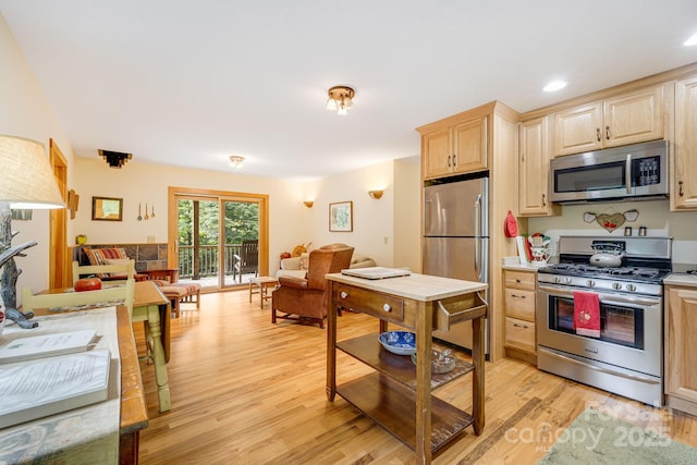 kitchen with stainless steel appliances, light hardwood / wood-style floors, and light brown cabinets