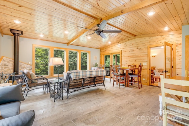 living room with plenty of natural light, wooden ceiling, and wood walls