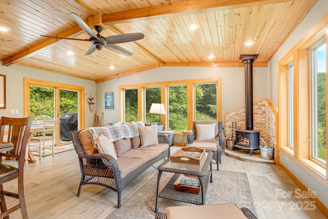 living room with vaulted ceiling with beams, light hardwood / wood-style flooring, wooden ceiling, and a wood stove