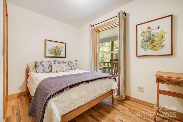 bedroom featuring access to exterior and light hardwood / wood-style flooring