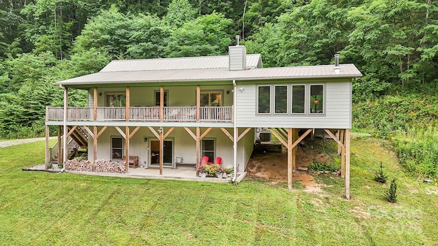 rear view of property with a yard, a patio, and a deck