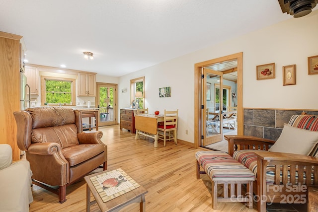 living area with light wood-style flooring and baseboards