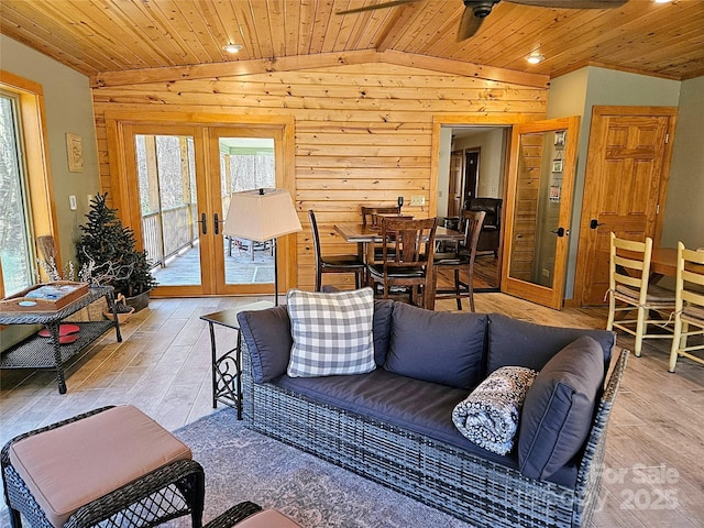 living area with french doors, wooden ceiling, ceiling fan, and vaulted ceiling