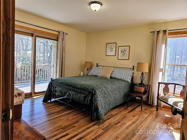 bedroom with wood finished floors and access to outside