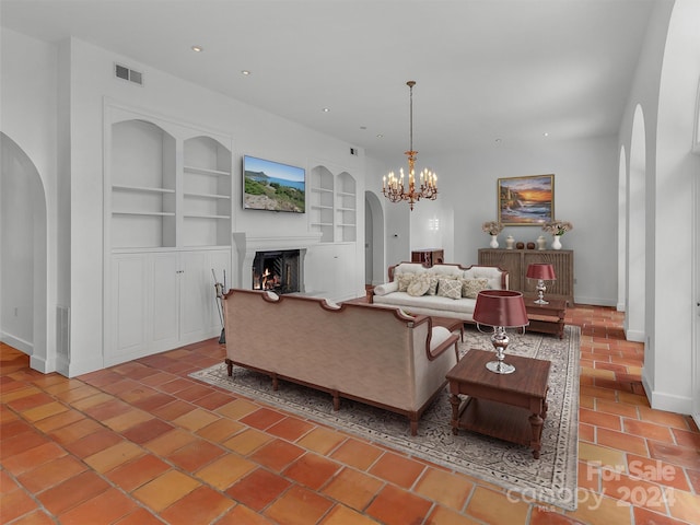 living room with built in shelves and a chandelier