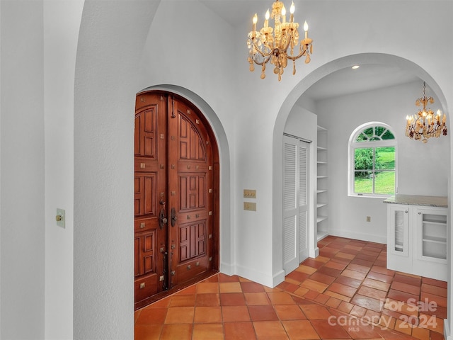 tiled foyer with a notable chandelier