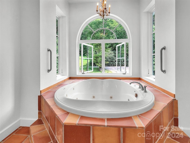 bathroom featuring tiled tub, tile patterned floors, and a chandelier