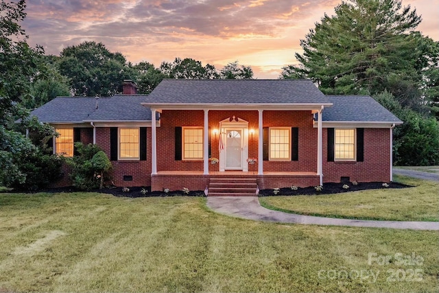 ranch-style house featuring a yard and covered porch