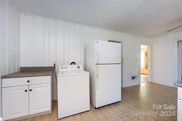 laundry area with wood walls and washer / dryer