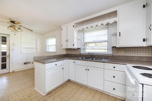 kitchen featuring a sink, visible vents, white cabinets, dark countertops, and white electric range oven