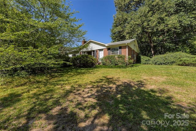 view of front of house featuring brick siding and a front lawn