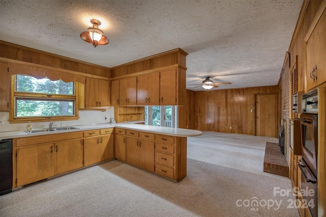 kitchen with a healthy amount of sunlight, wood walls, kitchen peninsula, and light carpet