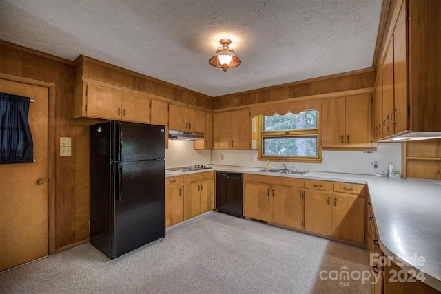 kitchen with wooden walls, sink, black appliances, and a textured ceiling