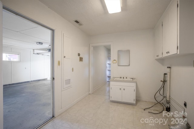 laundry room with sink and a textured ceiling