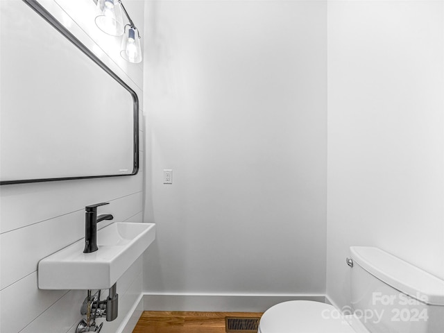 bathroom featuring wood-type flooring and toilet