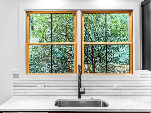 interior space with light stone countertops and sink