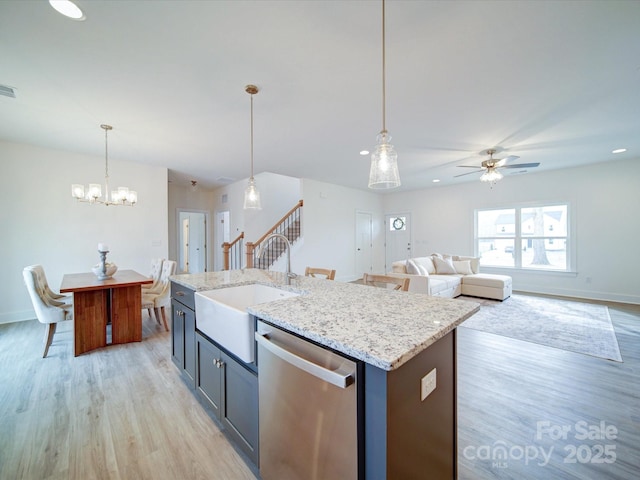 kitchen featuring pendant lighting, sink, a center island with sink, stainless steel dishwasher, and light wood-type flooring