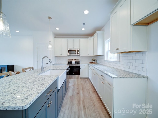 kitchen featuring stainless steel appliances, decorative light fixtures, blue cabinets, and white cabinets