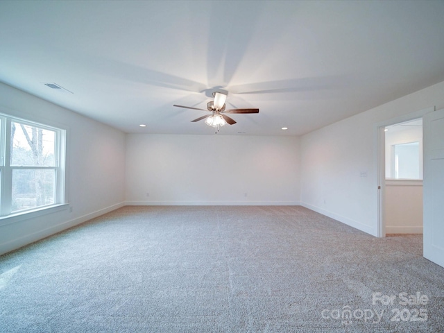 spare room featuring light carpet and ceiling fan