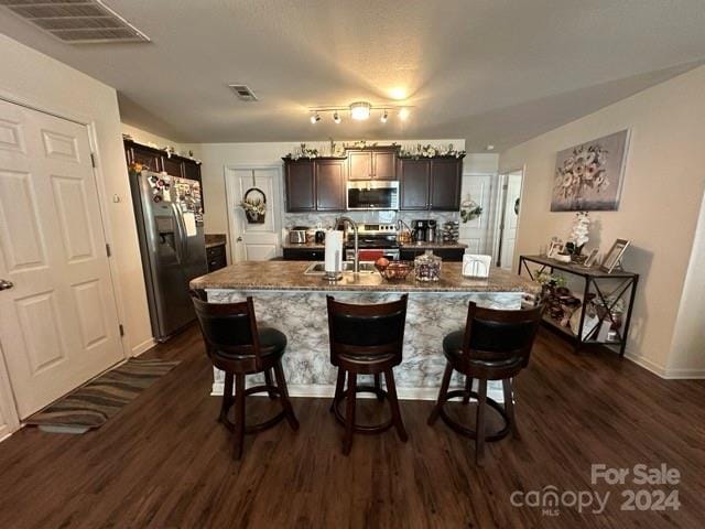 kitchen featuring a center island with sink, a breakfast bar, sink, and stainless steel appliances