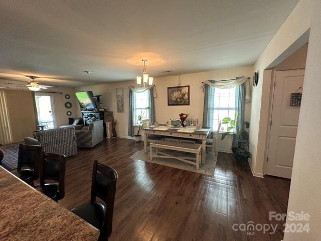 dining room featuring dark wood-type flooring and ceiling fan with notable chandelier