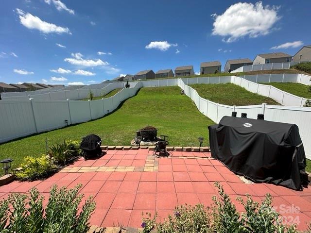 view of patio with area for grilling and a fire pit