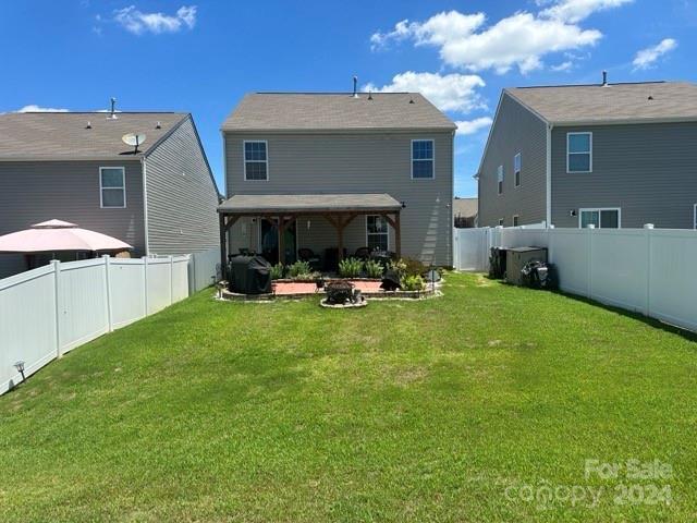 back of house with a yard and a patio