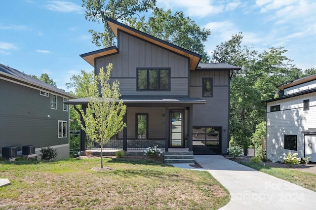 contemporary home featuring a front yard, a porch, and central AC