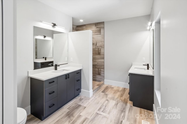 bathroom featuring toilet, walk in shower, and vanity