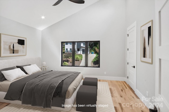 bedroom with light hardwood / wood-style floors, high vaulted ceiling, and ceiling fan