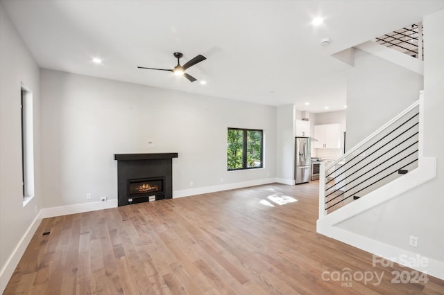 unfurnished living room with ceiling fan and light wood-type flooring