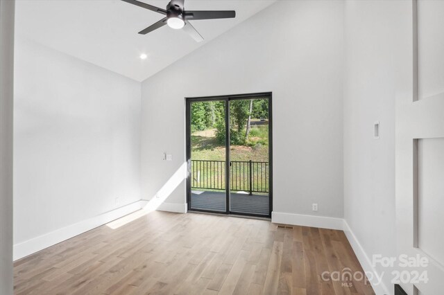 empty room with light wood-type flooring, ceiling fan, and high vaulted ceiling