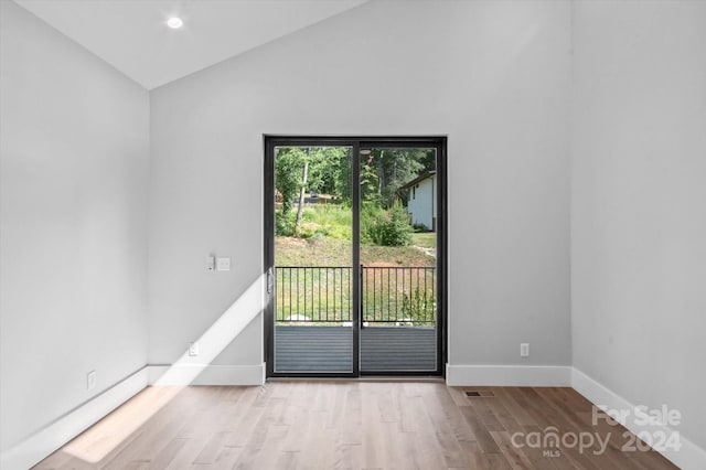 unfurnished room with vaulted ceiling and light hardwood / wood-style flooring