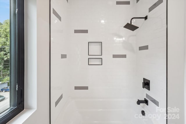 bathroom with tiled shower / bath combo and a wealth of natural light