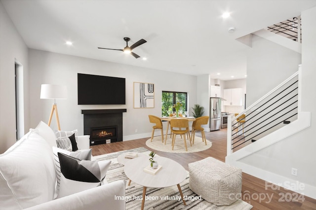 living room featuring ceiling fan and light hardwood / wood-style flooring