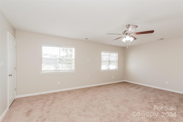 carpeted spare room featuring ceiling fan