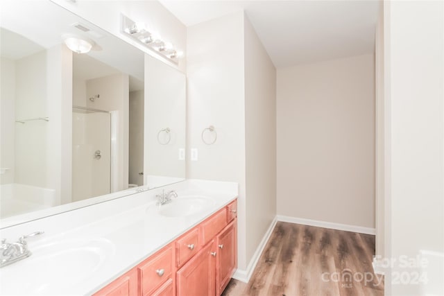 bathroom with vanity, hardwood / wood-style flooring, and walk in shower