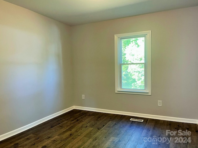 unfurnished room featuring dark wood-type flooring